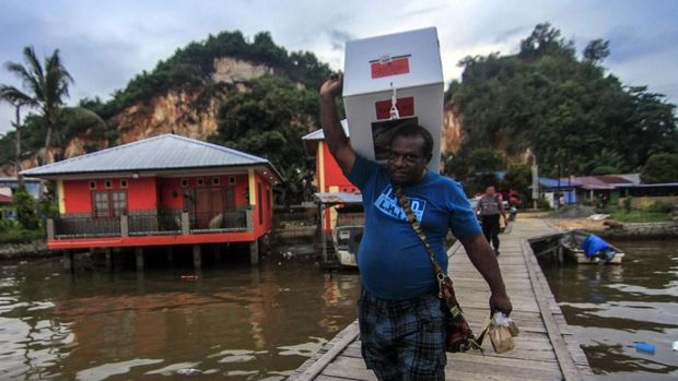 Petugas membawa kotak suara ketika melakukan pendistribusian logistik Pemilu 2019 di Kampung Kayu Pulo, Jayapura, Papua, Selasa (16/4).