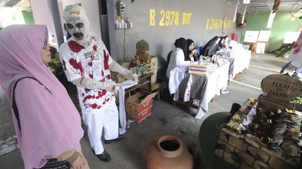 Petugas Kelompok Penyelenggara Pemungutan Suara (KPPS) menyambut warga yang akan menggunakan hak pilihnya dengan prosesi pedang pora di TPS 27 Kampung Happy, Manahan, Solo, Jawa Tengah