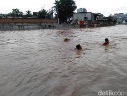 Remaja Kampung Pulo Berenang di Derasnya Sungai Ciliwung