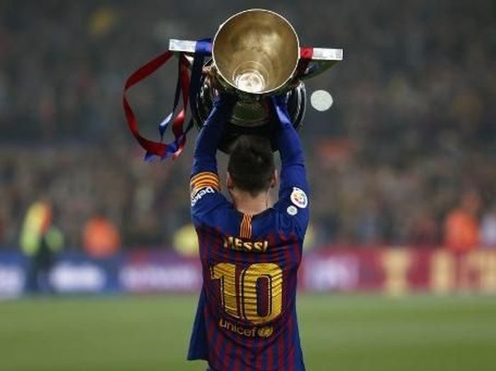 Lionel Messi mengangkat trofi LaLiga 2018/2019 di Camp Nou. (Foto: Pau Barrena/AFP)