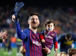 Messi saat menggendong sang anak. REUTERS/Albert Gea.
