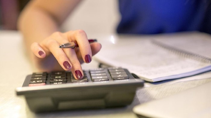 527041280 Close up of female accountant or banker making calculations