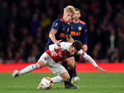 Lucas Torreira berebut bola dengan pemain Valencia di babak kedua. Torreira masuk pada menit ke-58 menggantikan Guendouzi. (Foto: Justin Setterfield/Getty Images)
