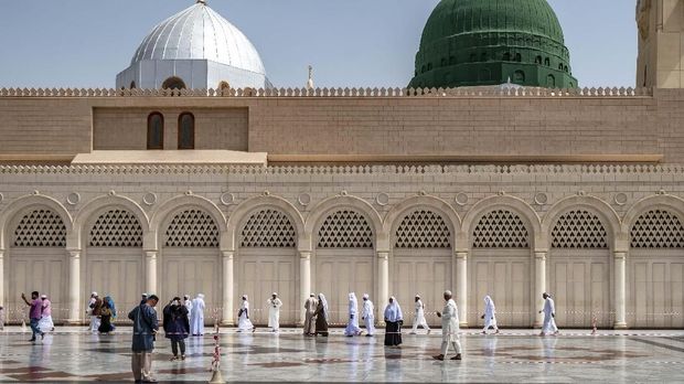 Pengunjung berjalan dengan latar kubah hijau yang menjadi lokasi makam Nabi Muhammad SAW, Abu Bakar as Siddiq, dan Umar bin Kattab di Masjid Nabawi, Madinah, Arab Saudi, Senin (6/5/2019). Ziarah makam Nabi Muhammad SAW dan dua sahabatnya tersebut menjadi salah satu aktivitas favorit Umat Islam saat berkunjung di Kota Madinah Al-Munawarah. ANTARA FOTO/Aji Styawan/foc.