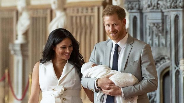Pangeran Harry menggendong putranya saat menunjukkan ke publik untuk pertama kalinya.