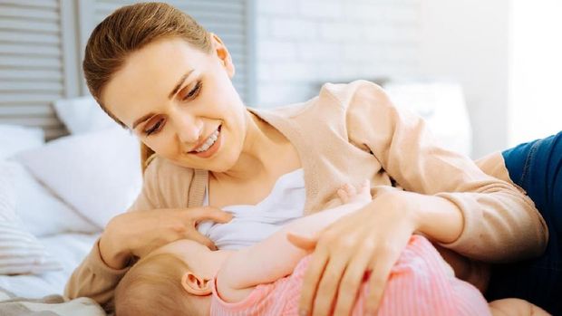 Precious moment. Caring loving woman being involved in an important process of breastfeeding a baby