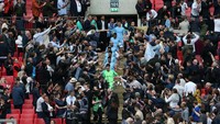 Seluruh tim Man City turun dari podium penyerahan trofi dan melanjutkan pesta di lapangan. (Foto: Alex Morton/Getty Images)