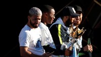 Sambil pamer piala, Sergio Aguero juga asyik bermain telepon selulernya di atas bus. (Foto: Lee Smith/Action Images via Reuters)