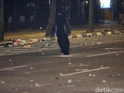 Perempuan Berpakaian Serbahitam dan Membawa Tas Berjalan ke Arah Bawaslu