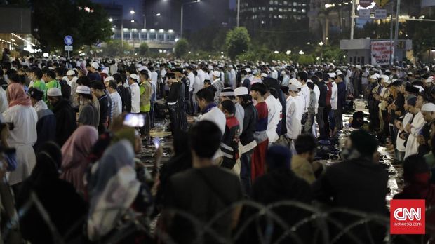 Massa pendemo salat magrib berjamaah di depan Gedung Bawaslu. (