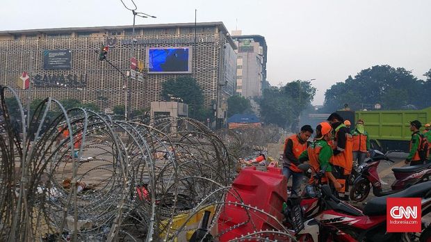 Petugas PPSU membersihkan sisa-sisa kerusuhan di Jl Thamrin depan gedung Bawaslu, Kamis (23/5) pagi.