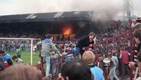 Terjadi kebakaran di Stadion Valley Parade, Bradford, Inggris dalam laga Bradford City vs Lincoln City. Api muncul ketika sorang penonton membuang puntung rokok ke celah belakang kursi yang terdapat tumpukan sampah. Ada 56 suporter tewas. (Foto: express.co.uk)