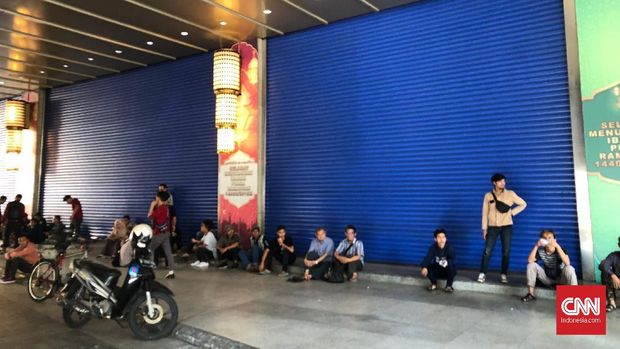 Sejumlah karyawan dan pemilik kios yang tak bisa masuk kerja karena penutupan pasar.