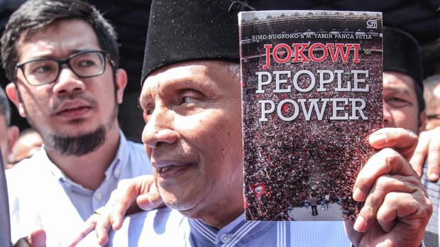 Ketua Dewan Kehormatan PAN Amien Rais memenuhi panggilan penyidik Polda Metro Jaya. Ia nampak membawa buku Jokowi People Power saat tiba di sana.