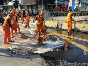 Aksi Petugas PPSU dan Damkar Bersihkan Jalan di Depan Bawaslu