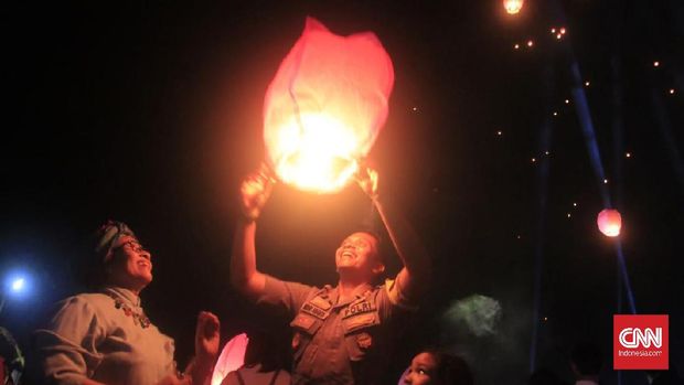 Umat Buddha menerbangkan lampion.