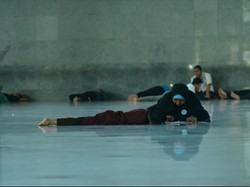 Seorang ibu yang mengajarkan anak BTQ saat bulan puasa.