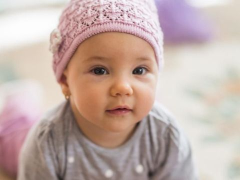 Cute Baby Girl Lying Down And Playing With Toy