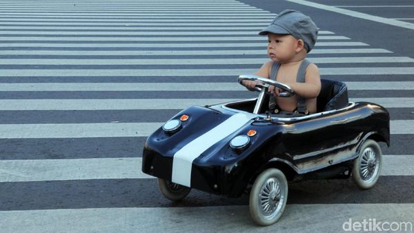 Lucu, Begini Gaya Balita Nyetir Mobil dan Mandi di Jalan Thamrin