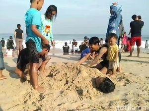 Yuk, LIhat Serunya Wisatawan Bermain di Pantai Santolo Garut