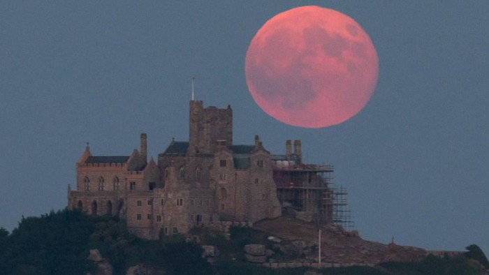 Ilustrasi Bulan, Bulan Stroberi MARAZION, ENGLAND - JUNE 28: A full moon rises behind St Michaels Mount in Marazion near Penzance on June 28, 2018 in Cornwall, England. Tonights strawberry moon, a name given to the full moon in June by Native Americans because it coincides with strawberry picking season, comes as parts of the UK continue to experience heatwave weather and record breaking temperatures. (Photo by Matt Cardy/Getty Images)