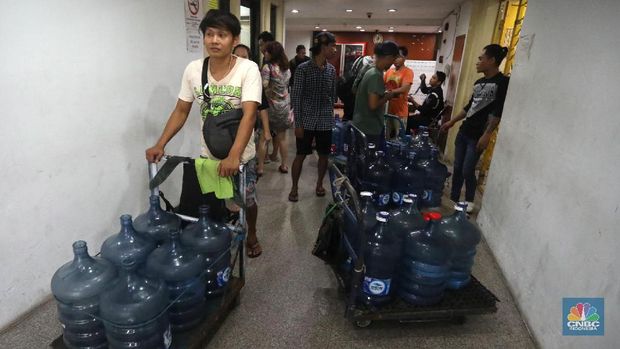 Pedagang air galon membawa galon nan sudah diisi penuh untuk dijual ke penduduk apartemen di Kawasan Pluit, Jakarta, Rabu (12/6). Banyak penunggu apartemen di area tersebut menggunakan air galon isi ulang untuk mandi. Mumun seorang pembantu rumah tangga mengatakan majiakannya bisa menkonsumsi air galon sehari 4-5 galon untuk mandi dan cuci piring. Harga galon isi ulang dia beli seharga Rp 3500 nan berasal dari air pam, Rp 7000 untuk galon isi ulang untuk galon original Rp.20.000. Banyak penunggu apartmen menggunakan air galon lantaran air nan mereka tempati kadang aroma dan kotor. (CNBC Indonesia/Muhammad Sabki)