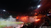 Asap putih tampak mengebul dari tribun stadion.