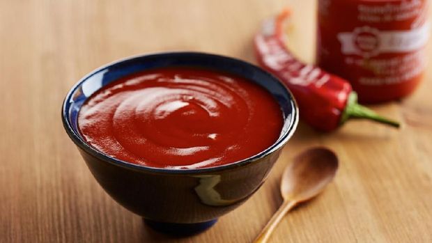 Bowl and bottle of sriracha sauce