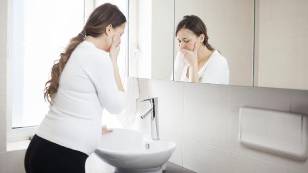 Young Pregnant Woman Suffering With Morning Sickness In Bathroom
