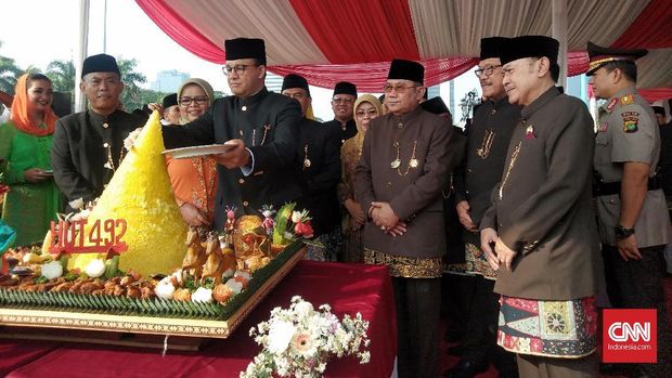 Gubernur DKI Anies Baswedan saat memotong tumpeng perayaan HUT DKI di Monas.