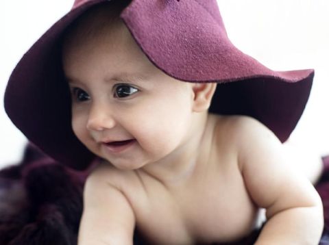 Beautiful baby on fur with hat and a cute smile , horizontal