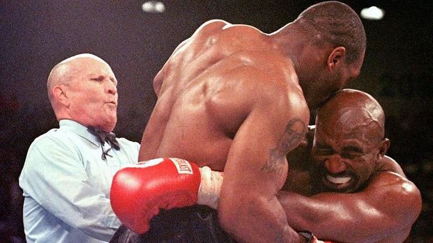 Referee Lane Mills (L) steps in as Evander Holyfield (R) reacts after Mike Tyson bit his ear in the third round of their WBA heavyweight championship fight at the MGM Grand Garden Arena in Las Vegas, NV 28 June. Holyfield won by disqualification after the biting incident.     AFP PHOTO/JEFF HAYNES (Photo by JEFF HAYNES / AFP)