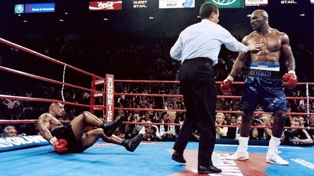 Challenger Evander Holyfield (R) reacts after his upset victory in his WBA championship bout with Mike Tyson on November 09, 1996 at the MGM Grand Hotel in Las Vegas, Nevada. Holyfield won the WBA heavyweight title with a technical knockout in the 11th round. (Photo by JEFF HAYNES / AFP)