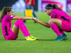 Kiper Jamaika, Sydney Schneider (kiri), dalam kekecewaan setelah timnya dipastikan tersingkir. Dia pun dihibur oleh Yazmeen Jamieson. (Foto: Maja Hitij/Getty Images)