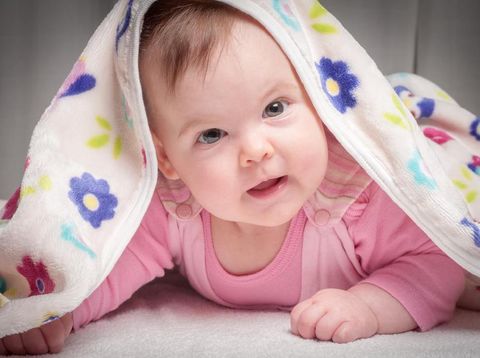 Smiling baby after shower with towel on head