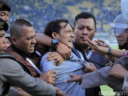 Sejumlah petugas berhasil mengamankan suporter tersebut.