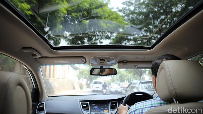 Panoramic Sunroof Pengendara mengendarai kendaraan beroda empat yang memiliki Panoramic Sunroof