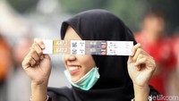 Seorang suporter menunjukkan tiket laga Persija vs Persib di SUGBK.