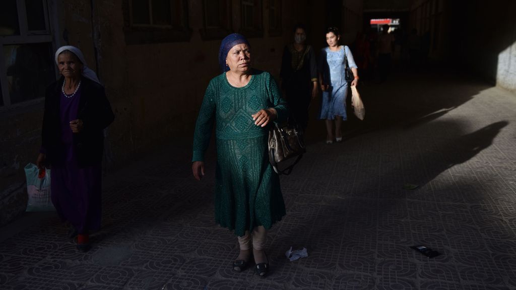 This photo taken on May 31, 2019 shows  Uighur women walking through a bazaar in Hotan in China's northwest Xinjiang region. (Photo by Greg Baker / AFP)