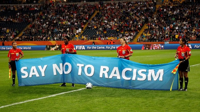 FRANKFURT AM MAIN, GERMANY - JULY 13:  The referees line up with a banner against racism prior to the FIFA Womens World Cup Semi Final match between Japan and Sweden at the FIFA World Cup stadium Frankfurt on July 13, 2011 in Frankfurt am Main, Germany.  (Photo by Friedemann Vogel/Getty Images)