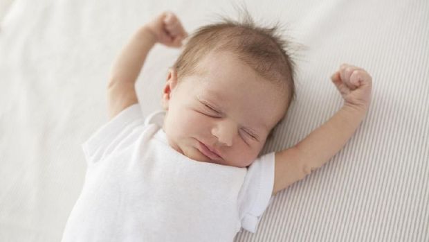 cute baby lying in bed and waking up