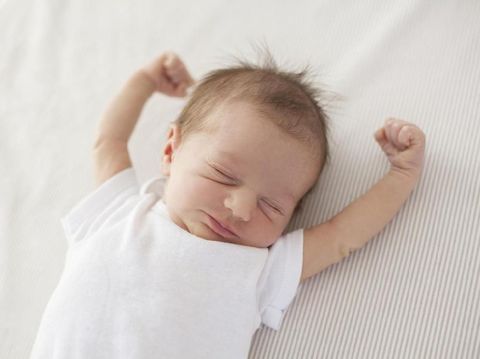cute baby lying in bed and waking up