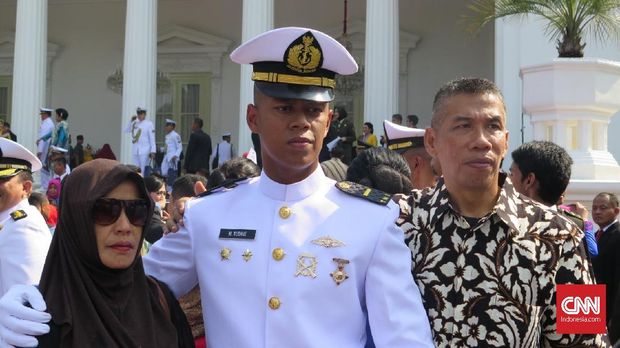 Letda M. Yudhie (tengah) bersama kedua orang tuanya usai pelantikan di Halaman Istana Merdeka, Jakarta, Selasa (16/7).