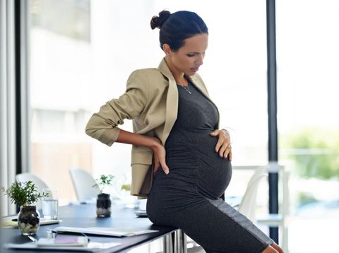 Shot of a pregnant businesswoman in discomfort in her office