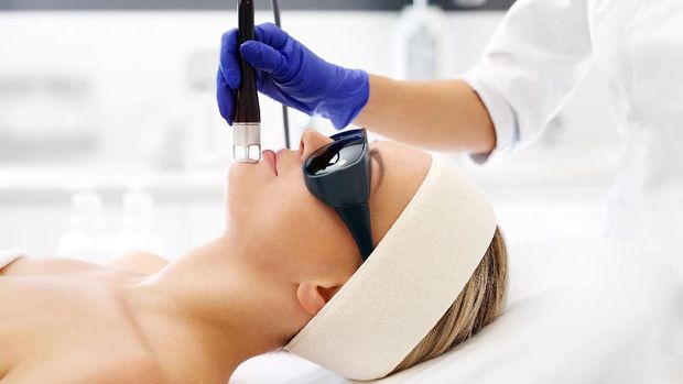 A woman in a beauty salon during a laser treatment.