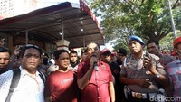 Panpel mengumumkan penundaan final Piala Indonesia dengan penjagaan polisi.