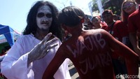 Seorang suporter datang dengan mengenakan kostum pocong. 