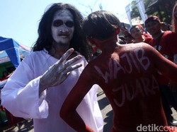 Seorang suporter datang dengan mengenakan kostum pocong. 
