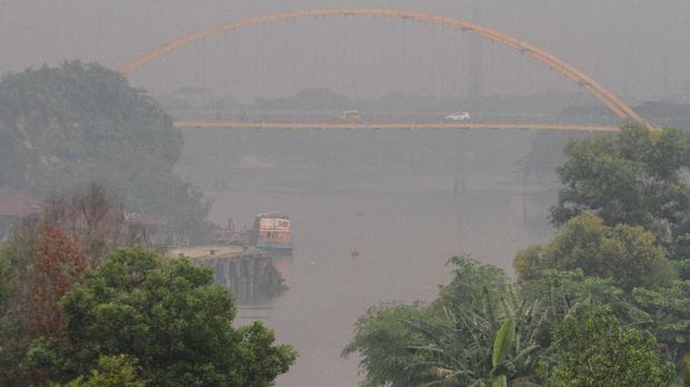 Kabut asap dampak dari kebakaran hutan dan lahan yang terjadi di beberapa wilayah di Provinsi Riau terlihat di kawasan Sungai Siak, Pekanbaru, Riau, Selasa (30/7/2019). BMKG Pekanbaru merilis terdapat sebaran 33 titik panas dengan level confidence 70 % yang tersebar di Kabupaten Bengkalis 2, Kampar 1, Rokan Hilir 8, Siak 1, Indragiri Hilir 14, Indragiri Hulu 2 dan Pelalawan sebanyak 30 titik. ANTARA FOTO/Rony Muharrman/foc.