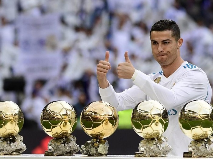 Real Madrid's Portuguese forward Cristiano Ronaldo poses with his five Ballon d'Or trophies ahead of the Spanish league football match between Real Madrid and Sevilla at the Santiago Bernabeu Stadium in Madrid on December 9, 2017. (Photo by PIERRE-PHILIPPE MARCOU / AFP)